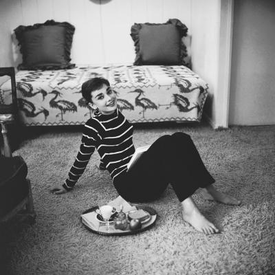 Mark Shaw Mark Shaw AUDREY HEPBURN IN STRIPED SWEATER LOUNGES ARMS BACK SMILING 1953