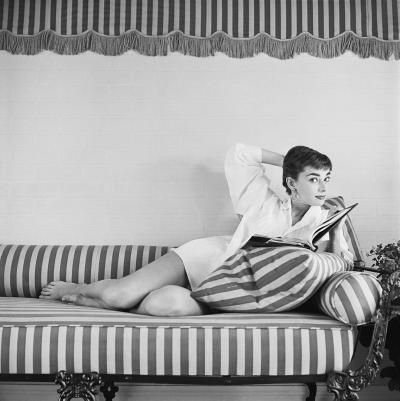 Mark Shaw Mark Shaw AUDREY HEPBURN ON STRIPED SOFA ARM BACK GLANCES RIGHT 1954