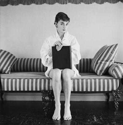 Mark Shaw Mark Shaw AUDREY HEPBURN ON STRIPED SOFA HANDS ON CLOSED BOOK 1954