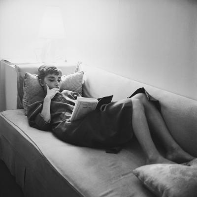Mark Shaw Mark Shaw AUDREY HEPBURN SUPINE READING ON COUCH 1953