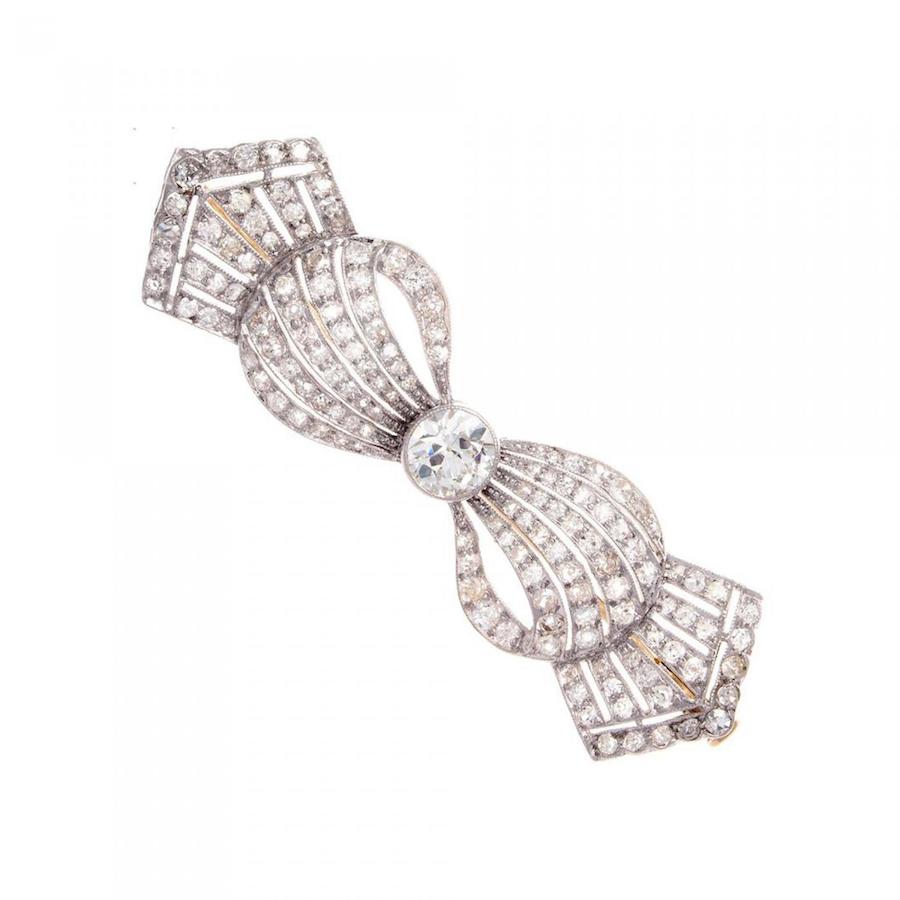 A smooth rhythmic art deco designed brooch that flows with fabric like ease. With an old European cut clean, white center diamond that weighs approximately 0.65 carats and is accented by 140 old cut diamonds weighing approximately 3.00 carats. Hand crafted in platinum. Offered by Jack Weir & Sons.