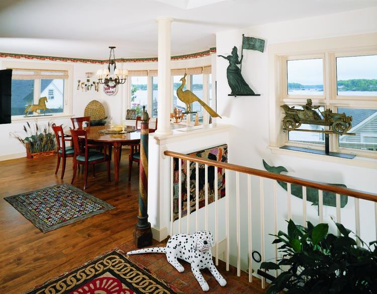 Views of the water surround the kitchen, where whimsical combinations of objects are arranged: Ice cream scoops from the turn of the 20th century hang on a wall above a rare 19th-century beehive apiary trade sign from Pennsylvania, which is in turn beside a series of “poor-man” silhouette decoys displayed hidden among some grasses. Hooked rugs add visual variety, as does the juxtaposition of a 19th-century barber pole and a contemporary carved dalmatian by Cuban-American folk carver Pucho Odio. The stairway provides display space for several important weathervanes: A peacock of 1883 by L.W. Cushing, desirable because of its extended tail; a late 19th-century Goddess of Liberty by Henis of Philadelphia; an early 20th-century full-bodied car and driver vane from the Vanderbilt estate; and an early 20th-century whale vane of wonderful form found in Maine. The hooked dog and star rug was a gift from a collector.