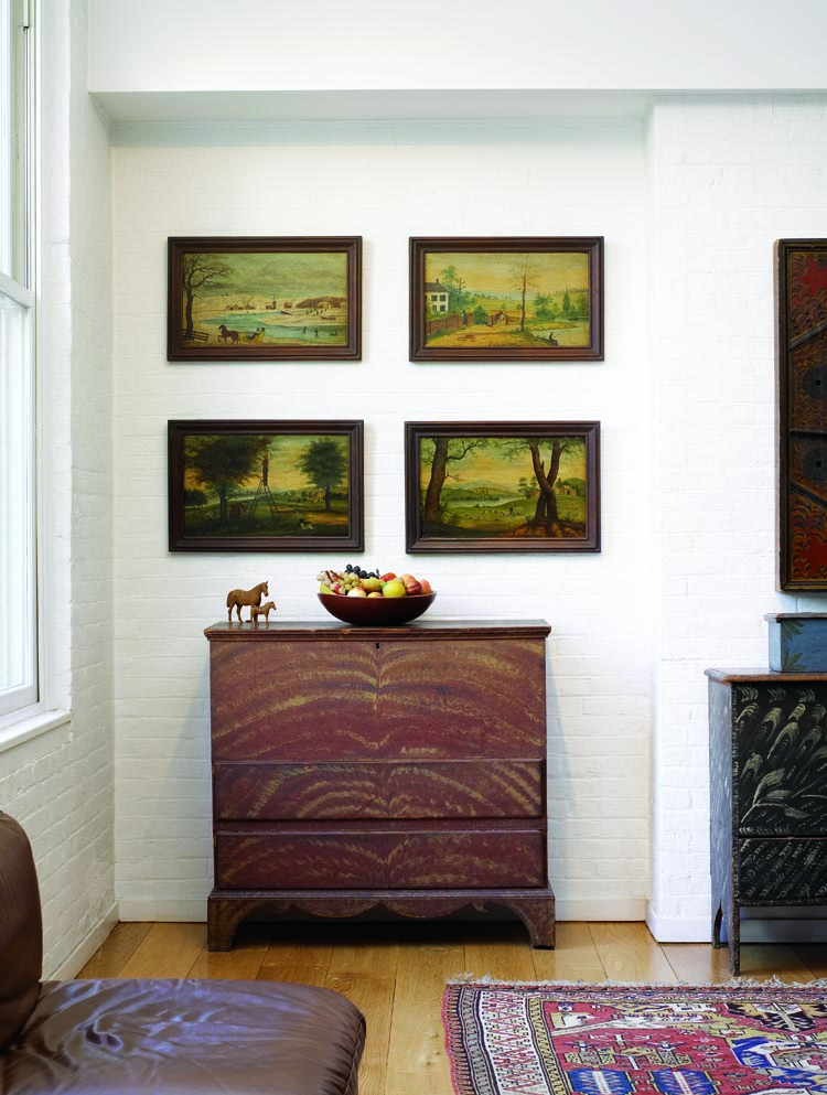 Four primitive oil-on-poplar paintings depicting the four seasons, in period frames, were created near Hoosick Falls, New York, near the Vermont border. They are signed and dated “A. Rogers 1863.” The two-drawer lift-top New England blanket chest of circa 1770–90 is painted with a tree of life on a red ground. It is topped with a basket of stone fruit.