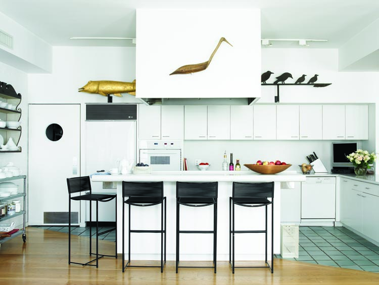“It’s charmingly loopy,” the husband says of the circa-1920 Midwestern sheet-iron weathervane of crows, partially visible at right, among the fin and fowl gathered in the kitchen. At left, the early 19th-century molded and gilded-copper fish weathervane, was found in a dealer’s shop on Cape Cod. The late-19th-century heron confidence decoy, center, is attributed to Lloyd Parker (1859– 1921) of Parkertown, N.J.