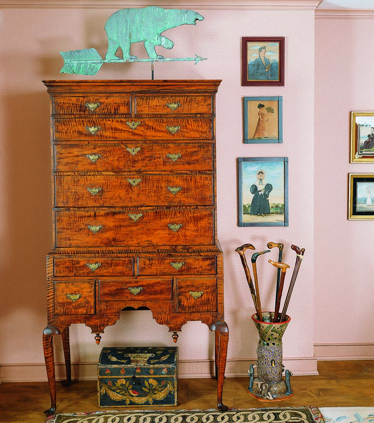 This Newburyport, Massachusetts, Queen Anne tiger maple high chest, ca. 1740–1760, from G.K.S. Bush is one of the few pieces of American furniture in the collection. The 1840 dome-top box with tole-type painted decoration is from the Barbara Johnson collection. Surmounting the high chest is a weathervane that was custom-made for the husband, an alumnus of Bowdoin College whose mascot is the polar bear. To the right are three watercolor paintings by Jacob Maentel (1763–1863) of Pennsylvania: a portrait of George Phillip Etchberger (purchased from David Wheatcroft); Woman with Fan (previously in several important collections including the Garbisch collection, Hirschl & Adler Galleries, and eventually to the Hoffman collection before being sold by Northeast Auctions to the couple); and Lady Holding a Book (purchased from Christie’s Scott sale in Pennsylvania). The pottery umbrella stand from Kentucky holds assorted folk art canes.