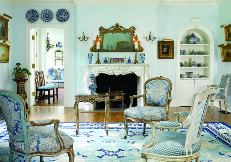In the living room, an antique French marble mantel is topped with a nineteenth-century neoclassical mirror, its original glass worn in places to a lovely tarnished patina; it was purchased from Gary Sargent Antiques of Woodbury, Connecticut. The chairs are eighteenth-century French. The late-nineteenth-century Chinese rug is a piece that the owner has cherished for forty-some years: “I had to have a house where I could use that rug,” she remarks. The living room’s decor, though somewhat formal, derives its relaxed air from the wife’s choices from a possible range of the “hundreds of blues” deployed throughout the interiors. Some of the collectors’ finest Dutch Delft pieces are displayed in the cabinet. “What I love about Delft is that the Dutch made plates to eat on every day,” the wife says, “and made very fine display pieces as well.”