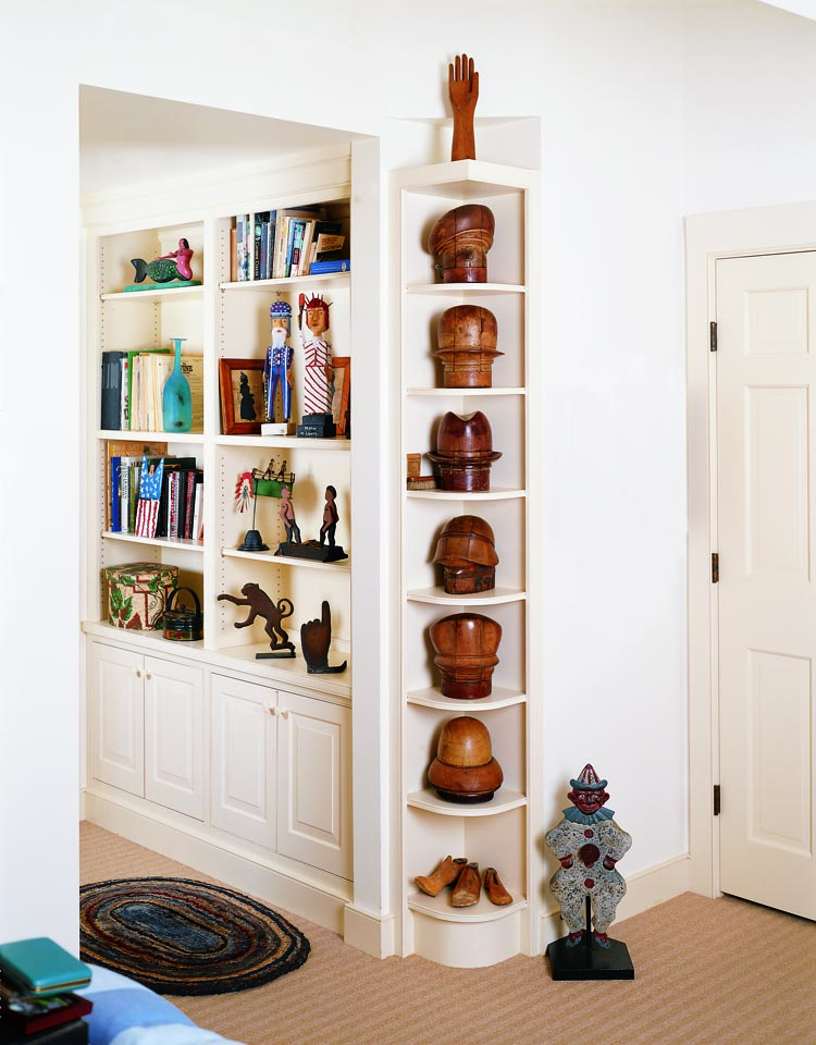 The corner shelves were added when the couple remodeled the house. Originally intended for books, the shelves proved to be the perfect size for a set of 1905 wooden felt-hat molds from the Empire Hat Company of New York, purchased from Wayne Pratt. An iron shooting gallery clown target is one of many figural targets displayed throughout the house.