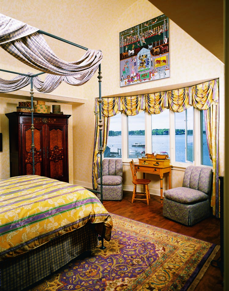 Memory of the Circus, a seminal oil on canvas by Albina Felski (1916–1996) hangs above the window in the master bedroom, which has a striking view of the water. The early 19th-century dressing table with original yellow paint and a fancy chair with grained seat are from Maine. One of the brushes seen on the dressing table is from Sotheby’s Bert and Nina Little sale.