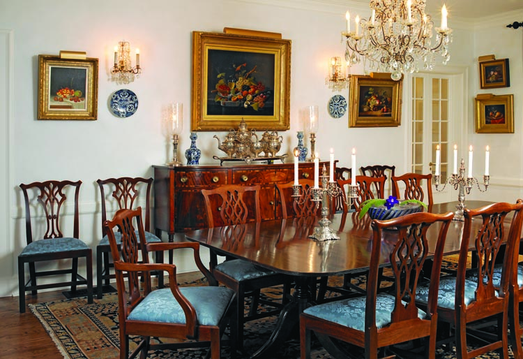 In the dining room, a table and eighteen chairs— a mix of original antiques and reproductions— “doesn’t begin to accommodate” the couple’s entire family, which includes seven children and seventeen grandchildren between them. A circa 1810 inlaid Federal sideboard attributed to Boston cabinetmakers John and Thomas Seymour displays a silver nineteenth-century Philadelphia tea service, and Dutch Delft “garlic” vases, which complement a breathtaking selection of still life paintings. Among them are William Mason Brown’s Still Life with Cherries and Fruit on a Marble Ledge with Wine Glass by Severin Roesen (1815–1871), both of which the collectors purchased from Godel & Co. To its right is Fruit Still Life, from MME Fine Art, painted in 1867 by Eliza B. Duffey who, during the 1860s worked as a still-life painter and writer in Woodbury, New Jersey, and in Philadelphia. At the far end of the room hang two small still lifes, the lower by Morston Constantine Ream and the top one by Adelaide Dietrich. The Roesen painting is one of the first paintings the couple bought after buying the house. Roesen continued the tradition established in seventeenth century Dutch and German still life painting, and became a pioneer of the genre in America.